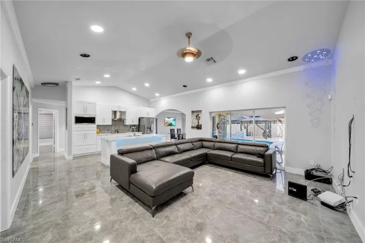 Living room featuring ceiling fan and ornamental molding