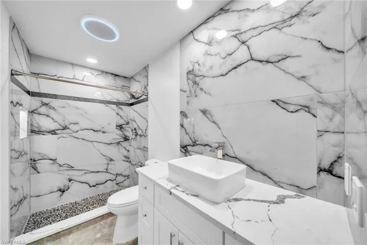 Bathroom with vanity, toilet, and a tile shower