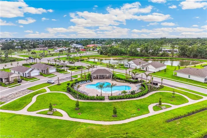 Aerial view of the community, featuring a swimming pool, a covered gathering area, and paved pathways