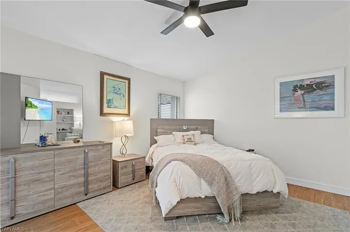Bedroom featuring light wood-style floors, vaulted ceiling, and a ceiling fan