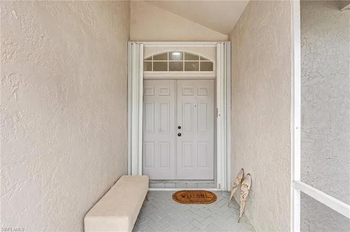 Doorway to property featuring stucco siding