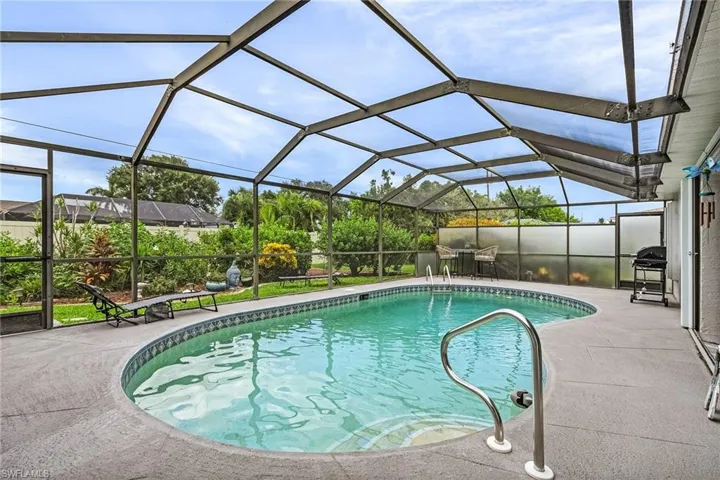 Swimming pool featuring a lanai, grilling area, a sunroom, and a patio area