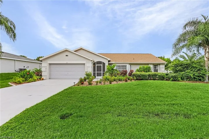 Ranch-style home featuring stucco siding, a front lawn, driveway, and an attached garage
