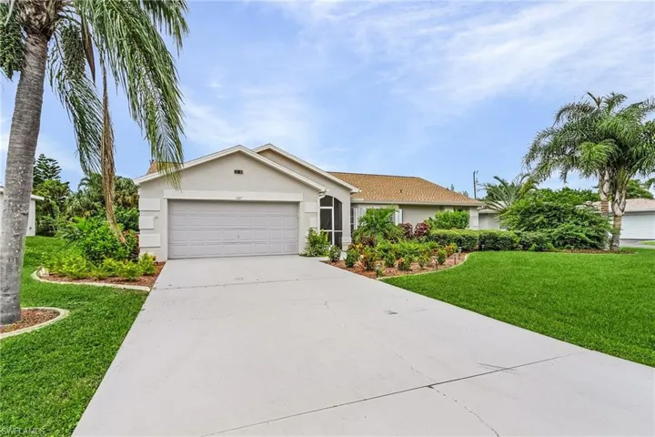 Ranch-style home featuring a front yard, stucco siding, concrete driveway, and a garage