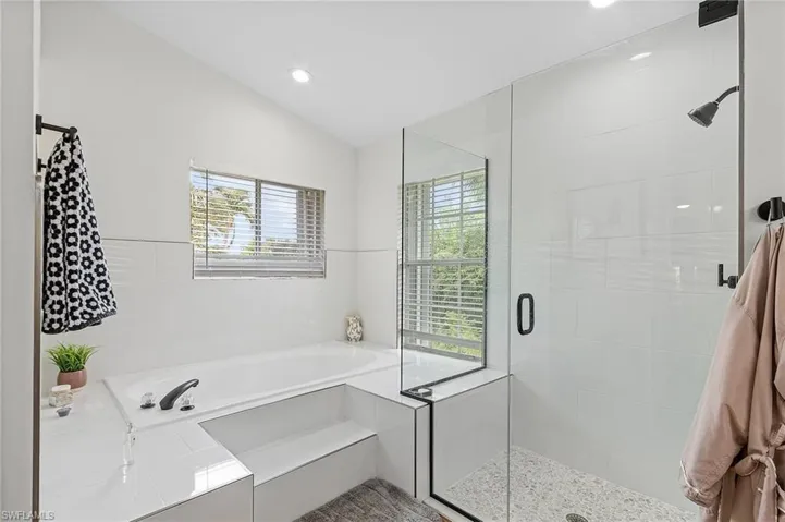 Full bath featuring a garden tub, a shower stall, lofted ceiling, and recessed lighting