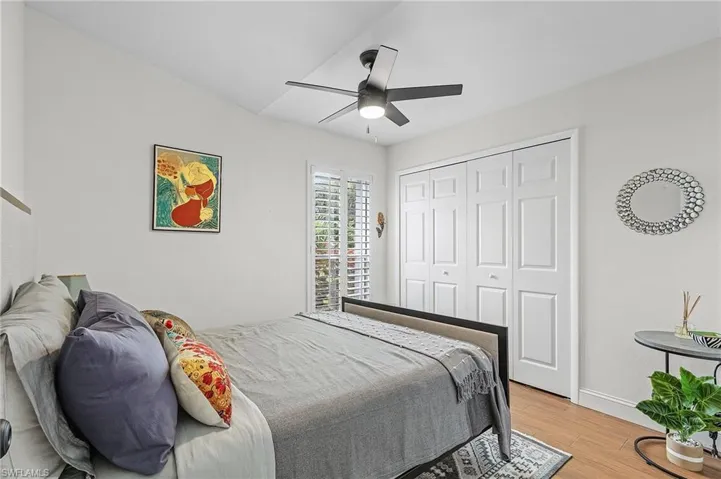 Bedroom featuring light wood finished floors, a ceiling fan, and a closet