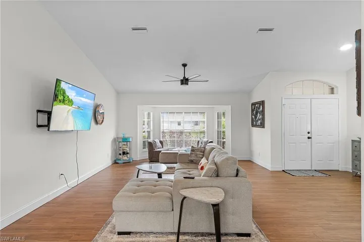 Living area with light wood-style floors and ceiling fan