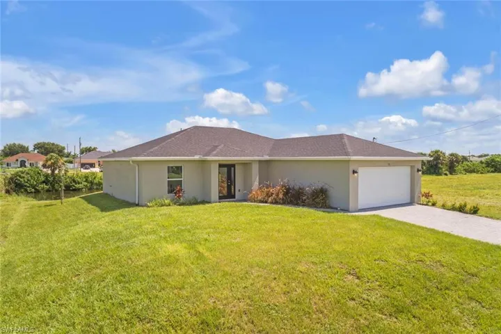 Single story home with a garage and a front yard