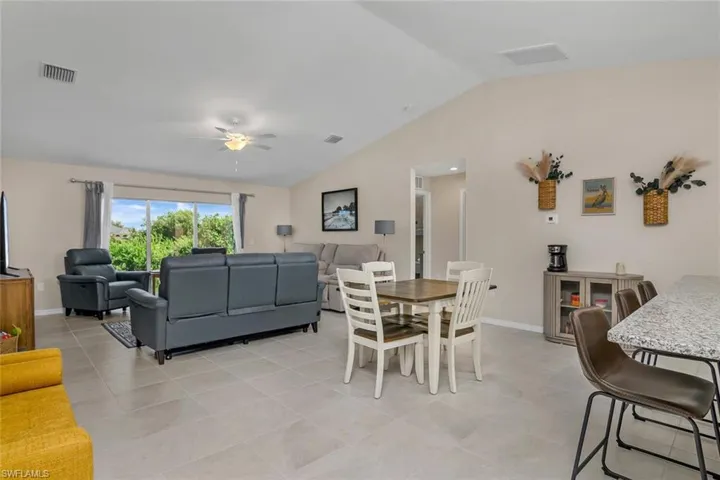 Tiled dining space featuring ceiling fan and vaulted ceiling