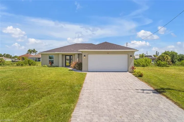 Ranch-style house with a garage and a front lawn