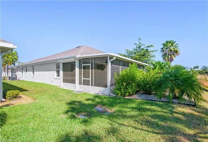 Back of house with a lawn and a sunroom