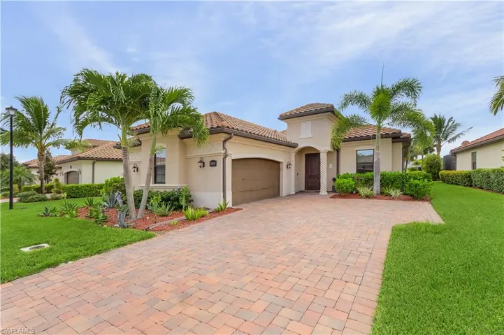 Mediterranean / spanish-style house with a garage and a front lawn