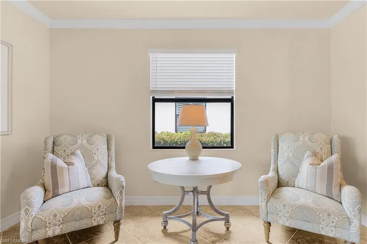 Sitting room with light tile patterned floors and ornamental molding