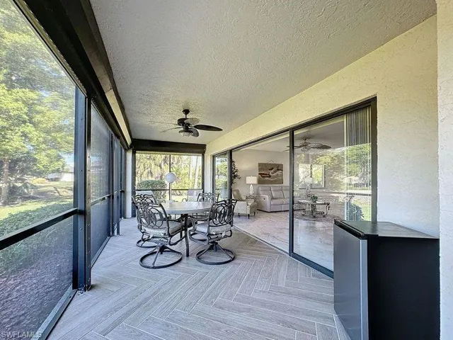 Unfurnished sunroom featuring ceiling fan