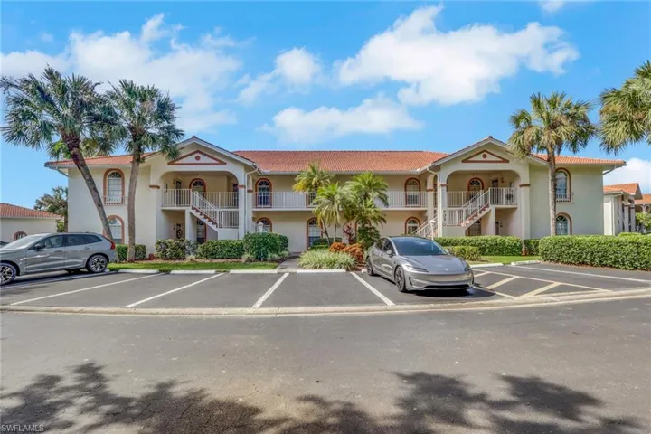 Two-story exterior featuring a tile roof, arched architectural detailing, and private balconies with white railings