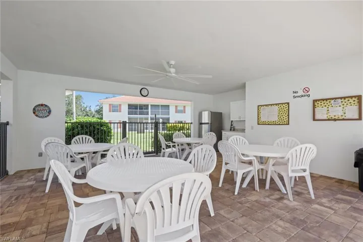 Covered patio featuring paver flooring, a ceiling fan, and a built-in kitchenette with cabinetry and a refrigerator
