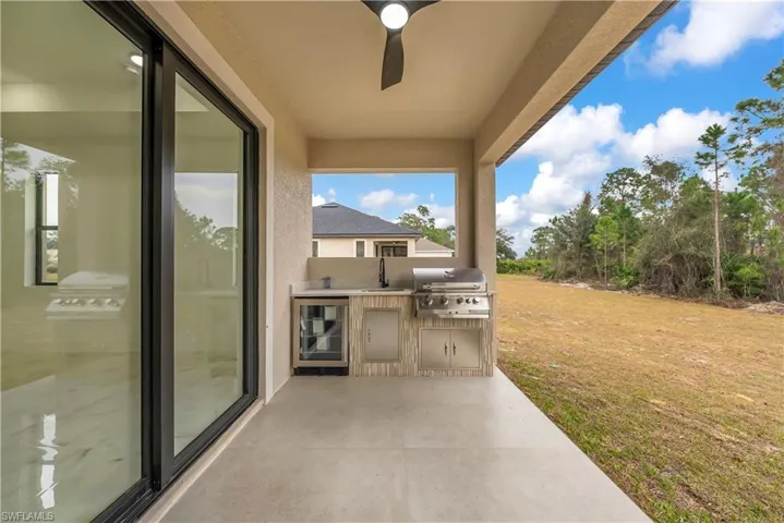 View of patio featuring exterior kitchen, ceiling fan, and wine cooler
