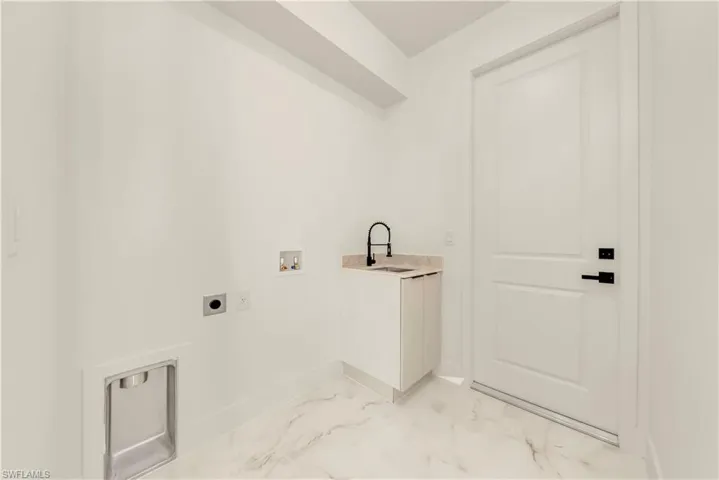 Laundry area featuring hookup for a washing machine, light marble finish flooring, and electric dryer hookup