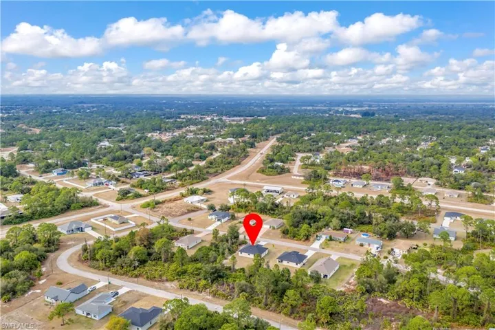 Aerial view of property and surrounding area featuring nearby suburban area