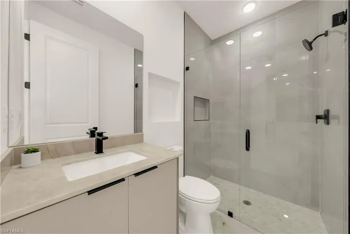 Full bath featuring vanity, a stall shower, and recessed lighting