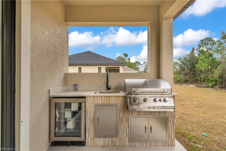 View of patio featuring beverage cooler and area for grilling