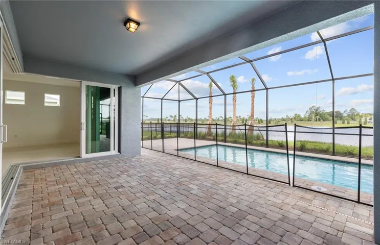 View of pool with a patio and glass enclosure