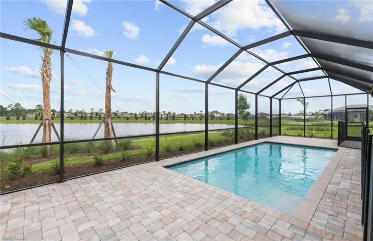 View of swimming pool with a water view, a patio area, and a lanai