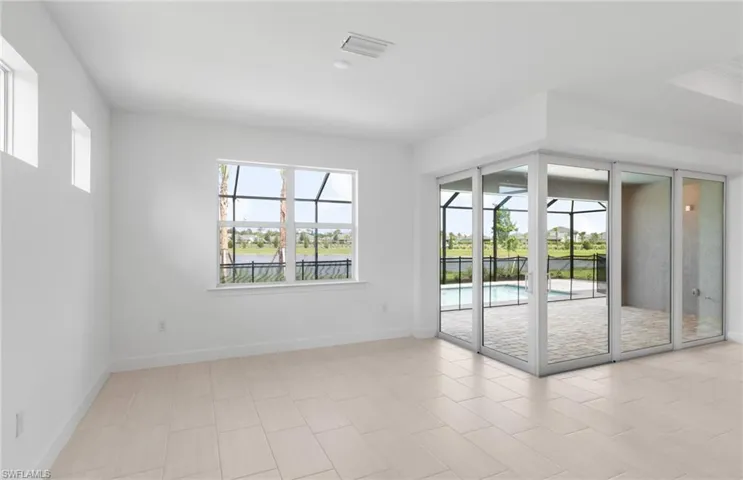 Empty room featuring light tile patterned flooring and a wealth of natural light