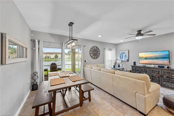 Living room featuring light tile patterned flooring, ceiling fan, and recessed lighting