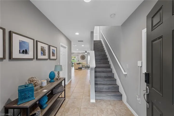 Foyer entrance with stairway, light tile patterned floors, recessed lighting, and ceiling fan
