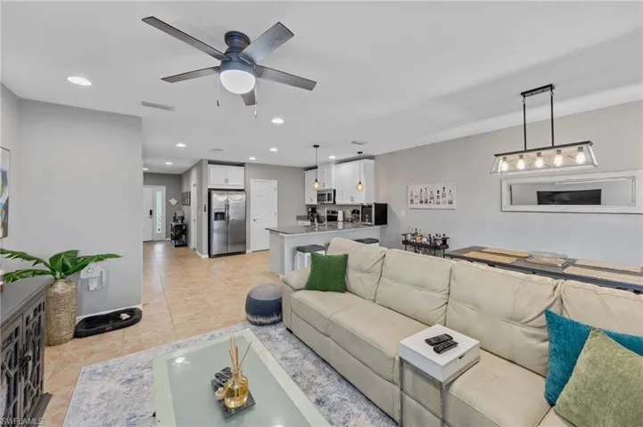 Living area with recessed lighting, ceiling fan, and light tile patterned floors
