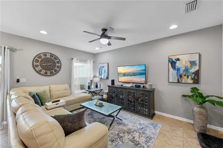 Living area with recessed lighting, ceiling fan, and light tile patterned flooring