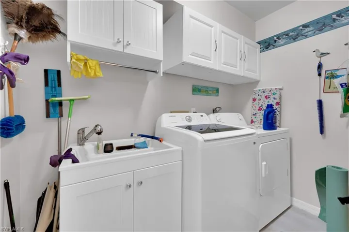 Washroom featuring cabinet space and washer and dryer