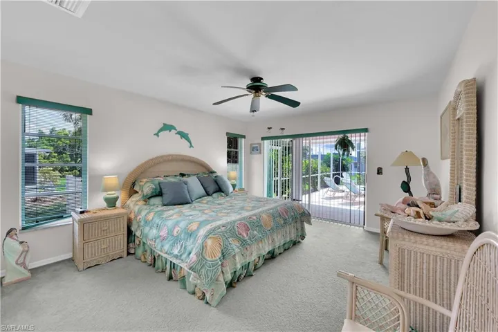 Carpeted bedroom featuring multiple windows, access to exterior, and ceiling fan