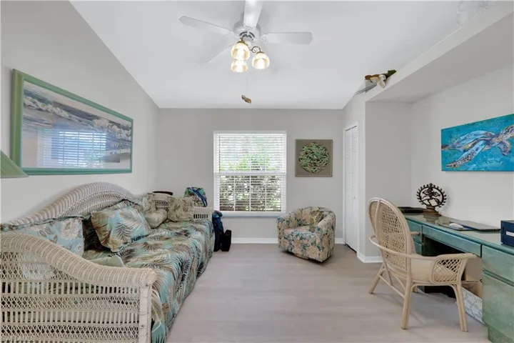 Living area featuring wood finished floors, an office area, and a ceiling fan