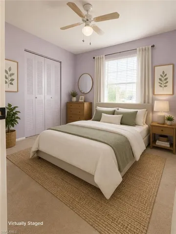 Bedroom featuring wall-to-wall carpeting, louvered bi-fold closet doors, a ceiling fan with light fixture, and a window with blinds