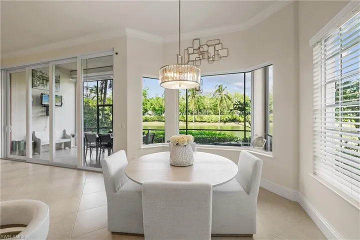 Dining space with ornamental molding, a healthy amount of sunlight, and light tile patterned flooring
