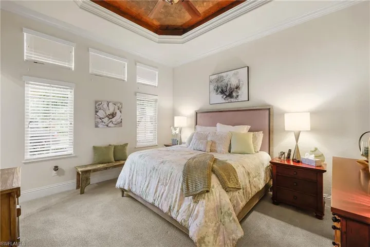 Bed 2 Ensuite featuring a lighted tray ceiling, ceiling fan, and crown molding