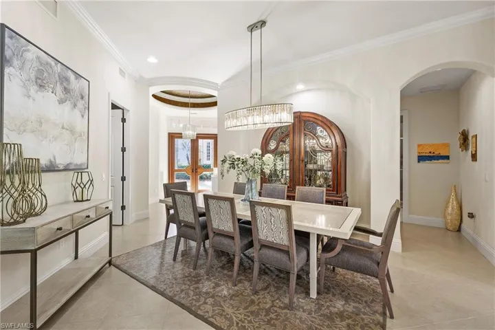 Dining space , ornamental molding,and an inviting chandelier