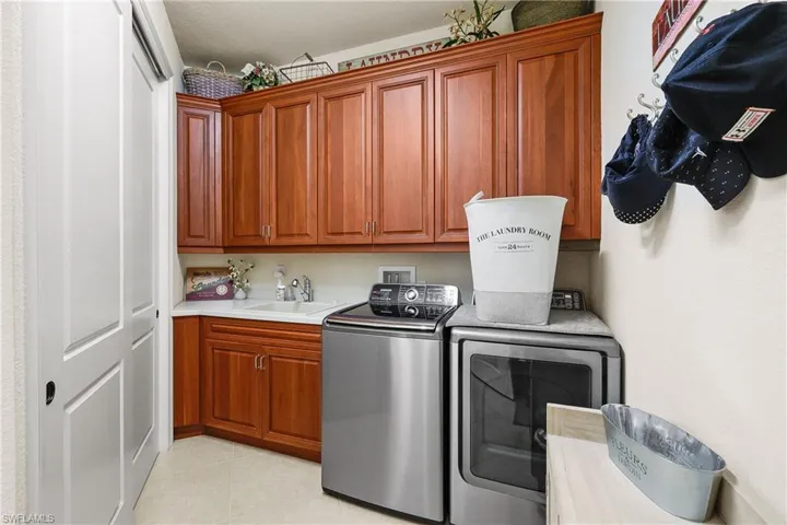 Laundry area with cabinets, washing machine and dryer, and sink