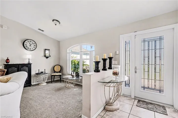 Living Room with light colored carpet and vaulted ceiling