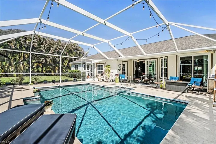 Outdoor pool with a patio, a sunroom, and glass enclosure