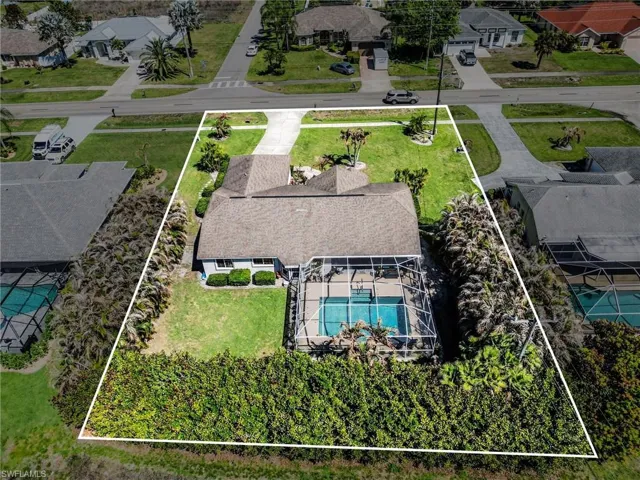 Aerial perspective of suburban area with property parcel outlined and a pool