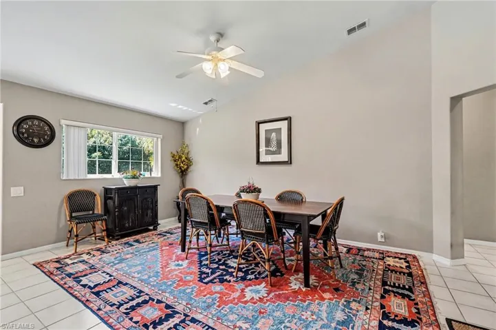 Dining space featuring light tile patterned floors, lofted ceiling, and ceiling fan