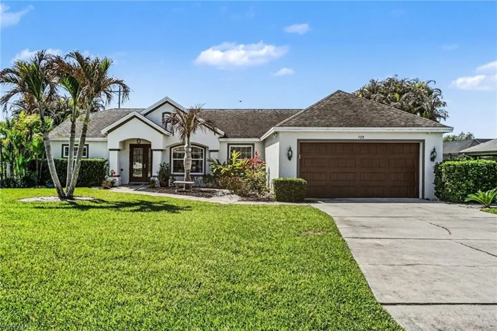 Single story home with stucco siding, an attached garage, concrete driveway, a front lawn, and roof with shingles