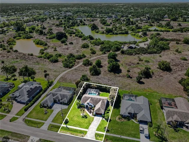 Aerial view of residential area featuring property parcel outlined and a large body of water