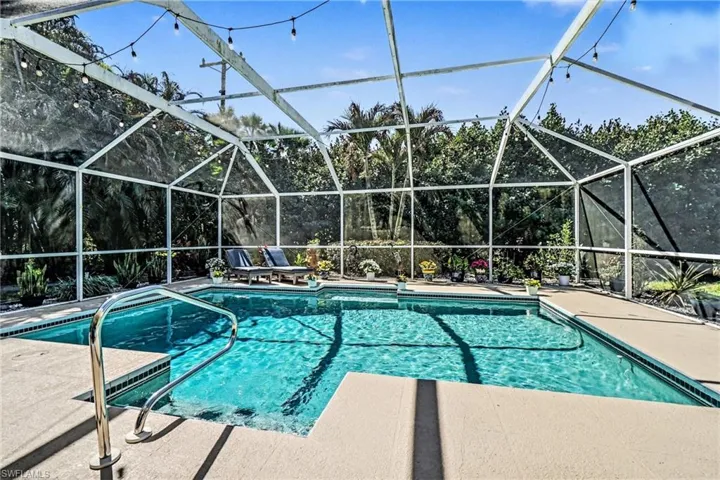Swimming pool featuring a sunroom, a lanai, and a patio