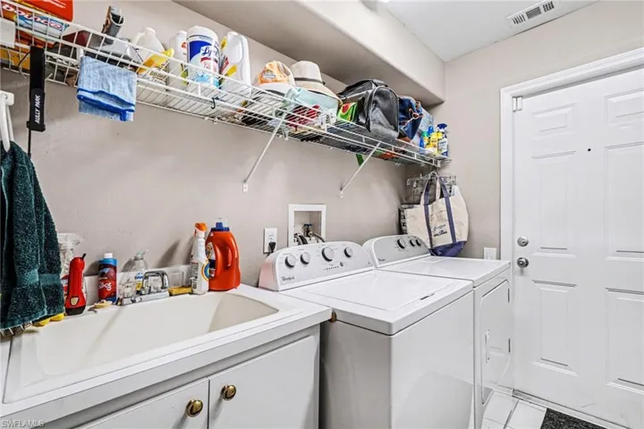 Laundry room featuring washing machine and clothes dryer and light tile patterned floors