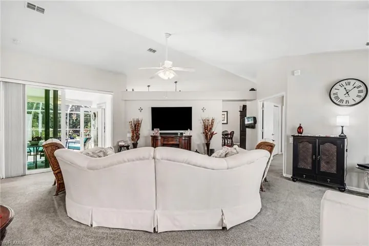 Living room featuring lofted ceiling, carpet floors, ceiling fan, and french doors