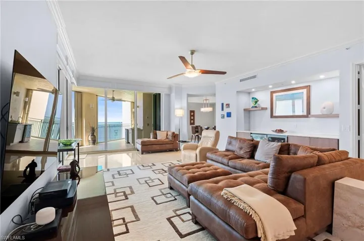 Living room featuring ceiling fan, light hardwood / wood-style flooring, and crown molding